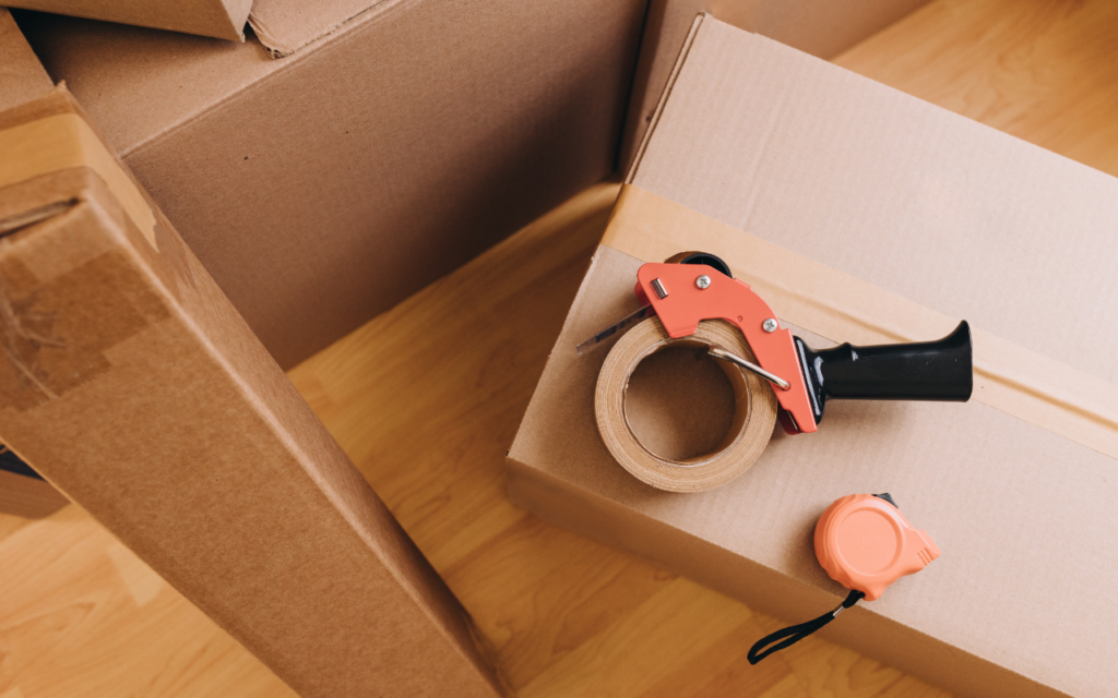 box with pink tape dispenser and pink measuring tape