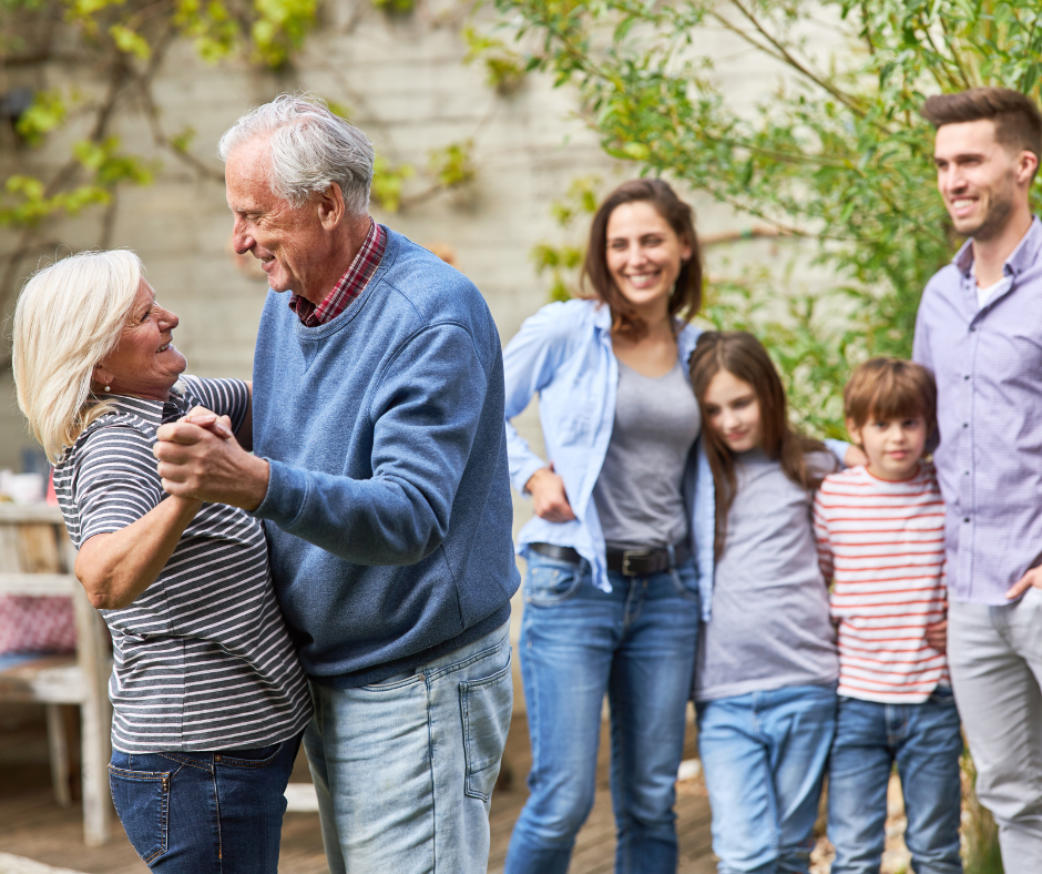 Image for blog - How Seniors can involve their families in the downsizing process Senior man and woman dancing while their adult kids and grandchildren watch